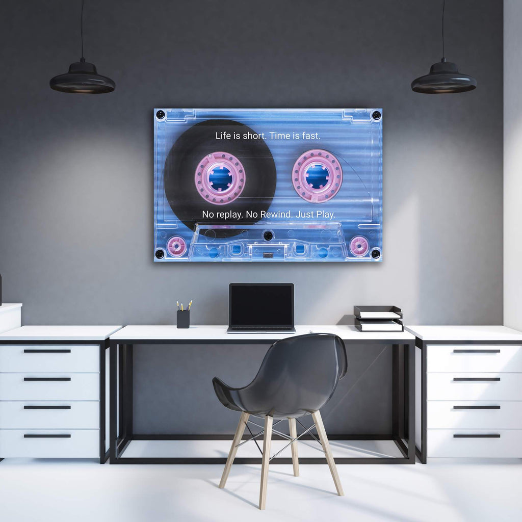 Cassette tape wall art with blue design, pink reels, and quote text