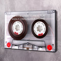 Framed cassette tape motivational wall art with two dark reels and white quote text