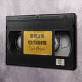 Black-framed wall art with cassette graphic and yellow quote label, “Own Movie”